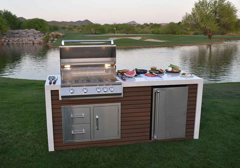 Kokomo waterfall-edge outdoor kitchen island with open grill, refrigerator, drawers and access door beside a pond