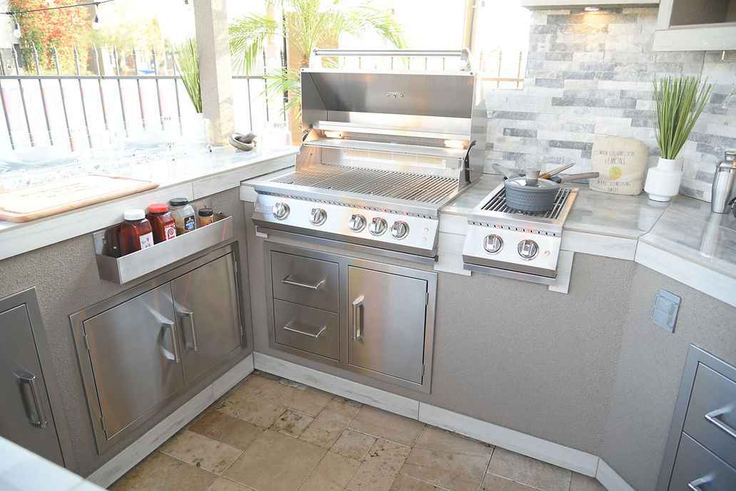 Kokomo grill and side burner with cookware, stainless steel drawers, access doors and countertop storage.