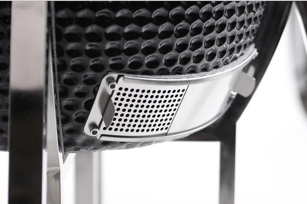 Close-up of the metal lower airflow vent on the black ceramic grill body.