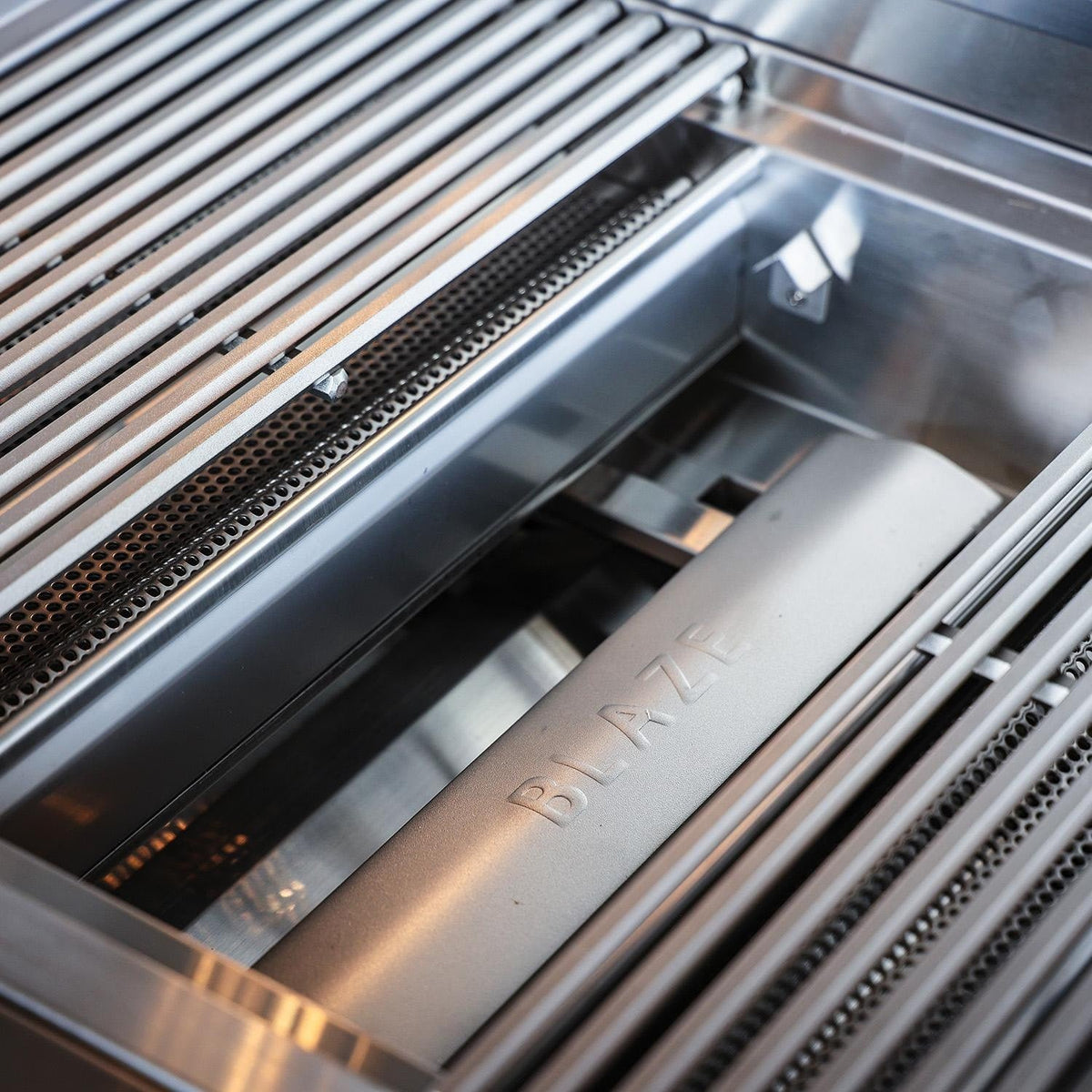 Blaze LTE PRO burner exposed beneath a removed cooking grate and flame tamer