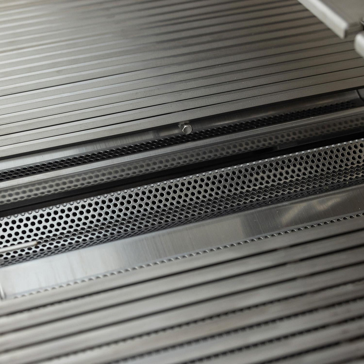 Detail of Blaze LTE PRO cooking grates with perforated flame tamers visible below