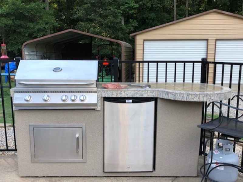Front view of Kokomo Maui Island with closed grill, refrigerator, stainless steel access door and round bar.