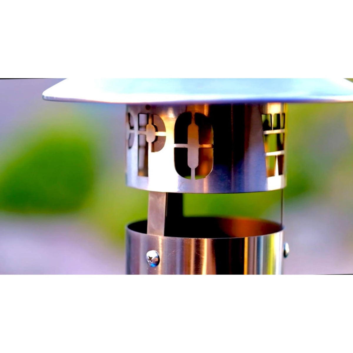 Close-up of the oven chimney cap with cutout lettering and supporting metal straps.
