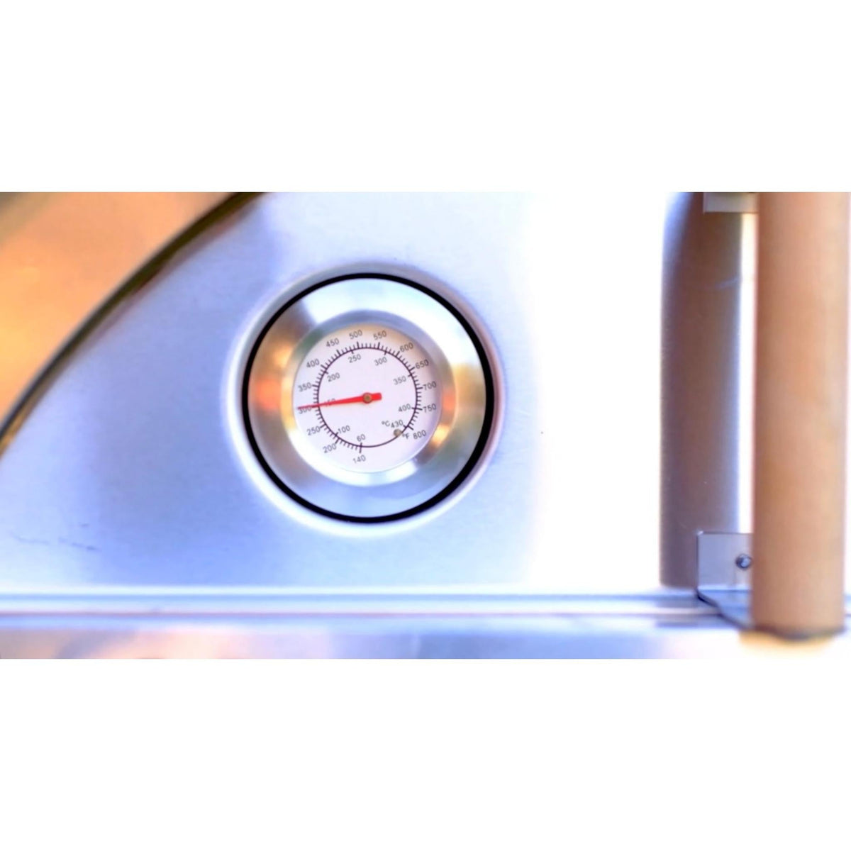 Close-up of the round thermometer mounted beside the WPPO Karma oven opening.