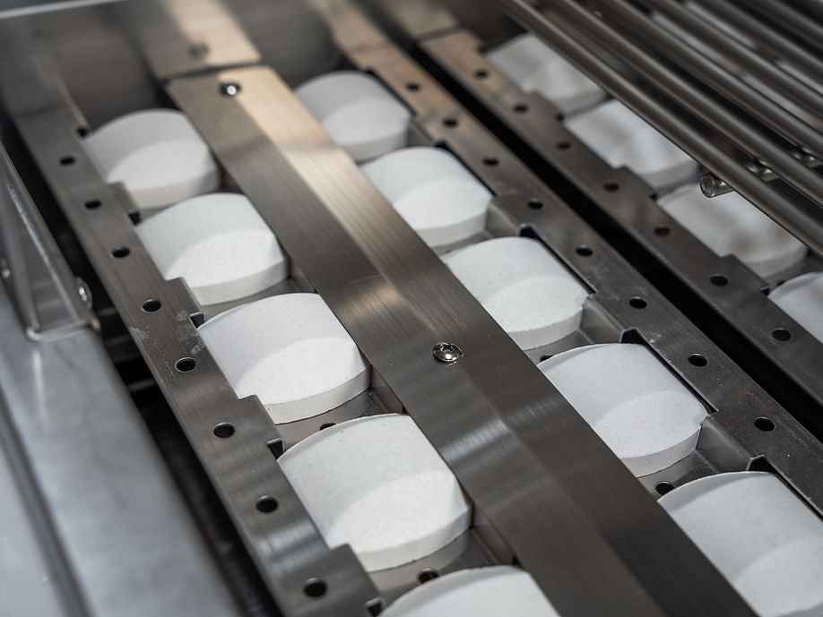 Close-up of white heat-distribution briquettes beneath the grill’s cooking grate.