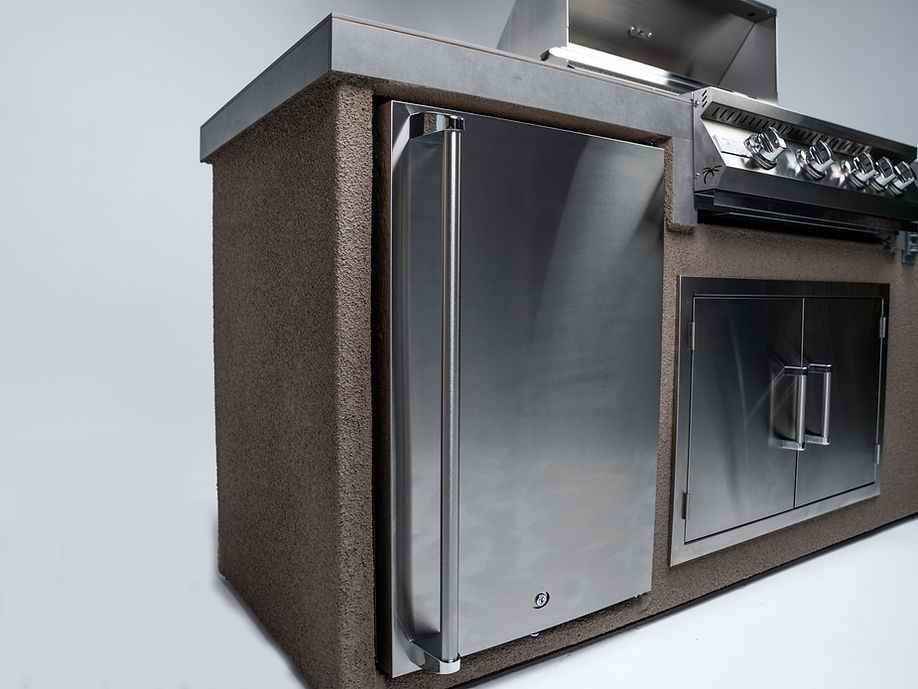 Angled view of the island’s stainless-steel refrigerator beside the grill and double access doors.