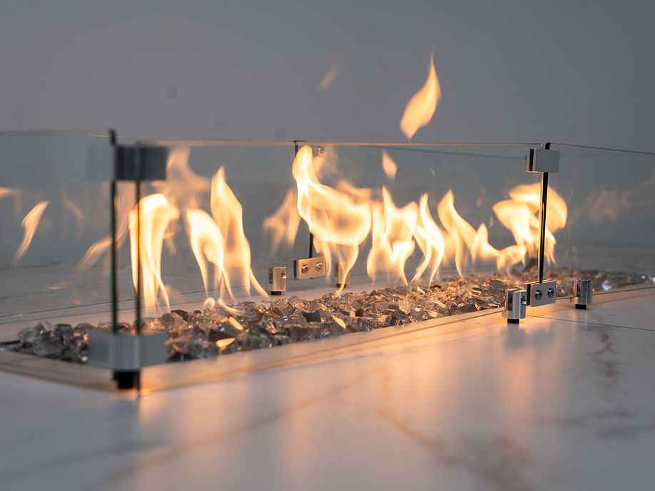 Close-up of the lit countertop fire feature with glass panels and decorative fire media.