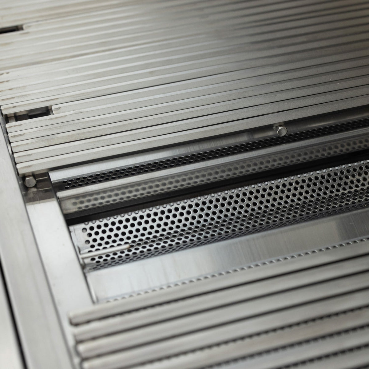 Close-up of Blaze LTE PRO cooking grates and perforated flame tamers beneath