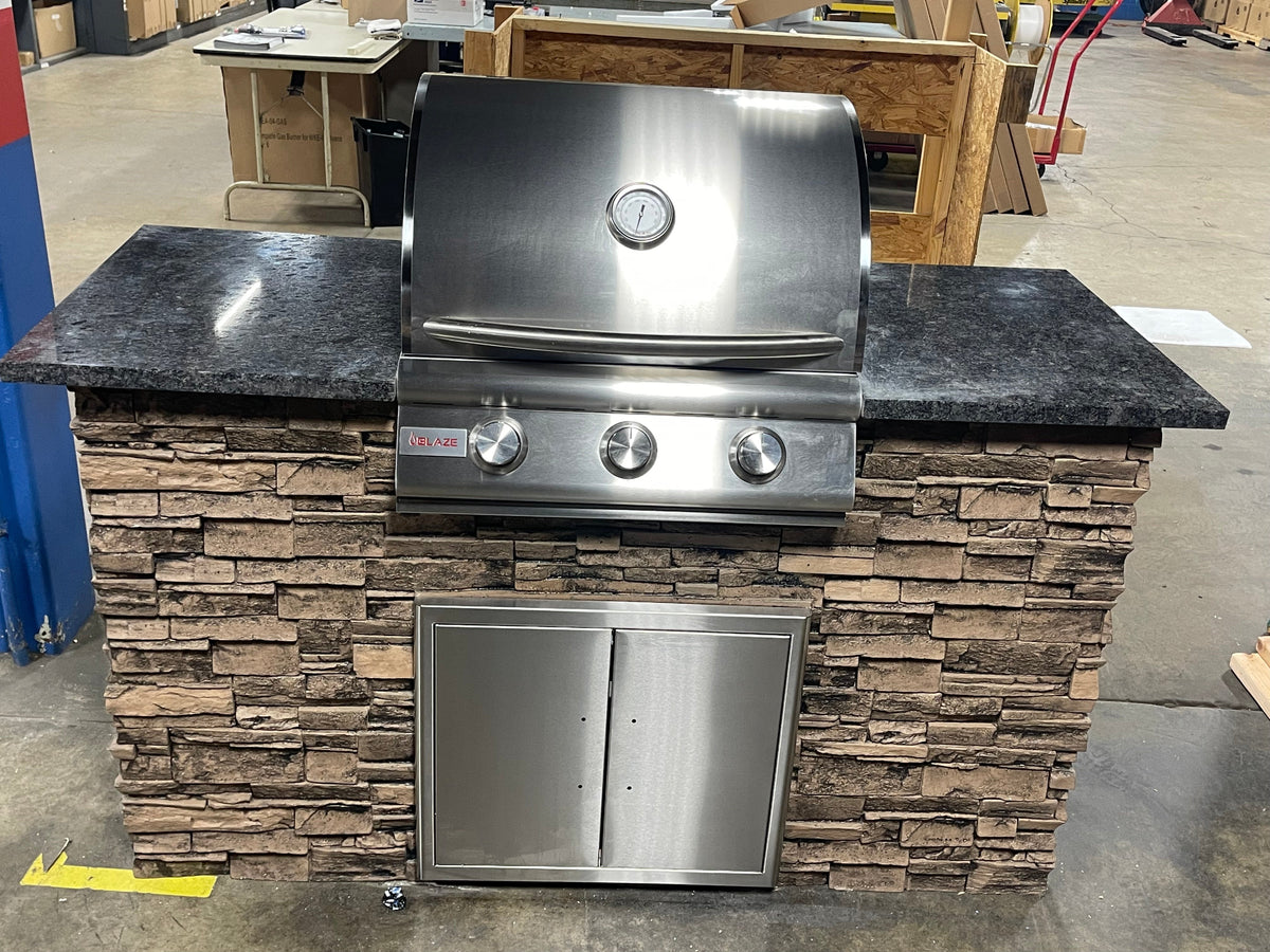Elevated view of WPPO stone-faced island with countertop space beside a Blaze grill and double access doors below.