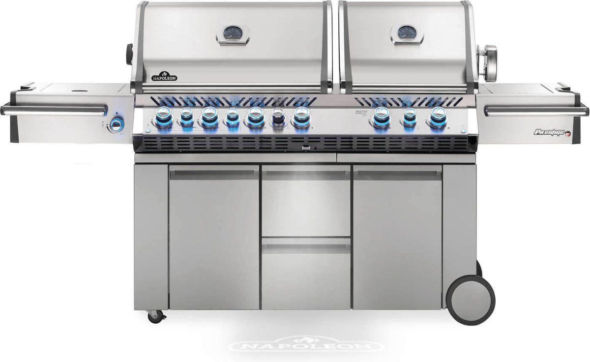 Front view of Napoleon Prestige PRO 825 gas grill with dual closed lids, blue illuminated knobs and cabinet storage.