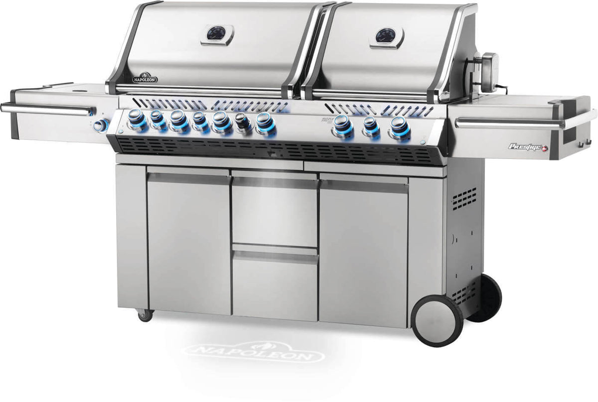 Angled view of Napoleon Prestige PRO 825 gas grill with dual closed lids and blue illuminated control knobs.