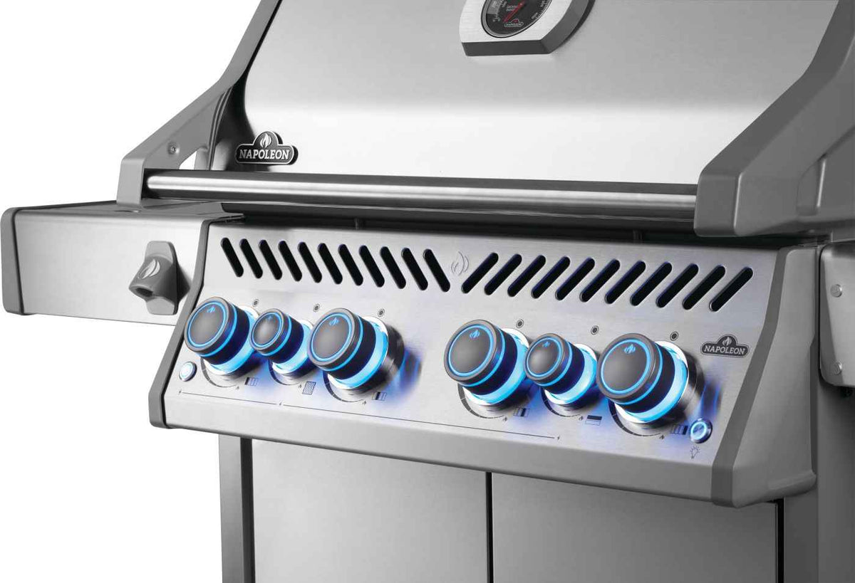 Angled close-up of Rogue PRO-S 525 RSIB gas grill controls with blue illuminated knobs.