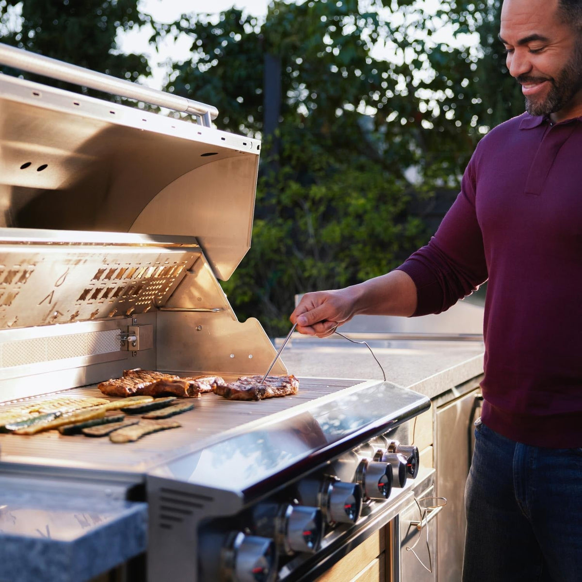Person checking steak temperature with a meat probe on a Blaze LTE PRO grill