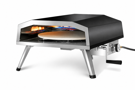 Black outdoor pizza oven with silver folding legs, circular pizza stone, side-mounted manual rotation handle, and propane hose.